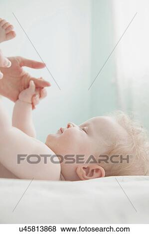 Stock Photo - Mother and baby daughter, holding hands. Fotosearch