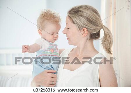 Stock Photography - Mother holding baby daughter. Fotosearch
