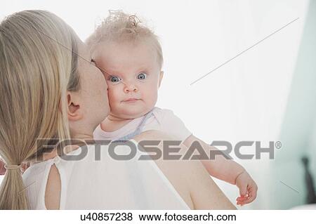 Stock Photo - Mother kissing baby daughter. Fotosearch