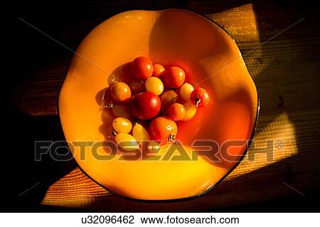 Overhead view of tomatoes in orange bowl on wood table View Large Photo Image Stock Image - Overhead view of tomatoes in orange bowl on wood table. Fotosearch