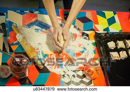 Overhead view of womans hands shaping dough at kitchen table View Large Photo Image Stock Photo - Overhead view of womans hands shaping dough at kitchen table. Fotosearch