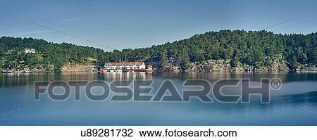 Stock Image - Panoramic view of fjord and distant village, Mosterhamn, Norway. Fotosearch