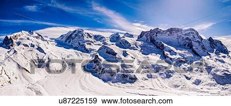 Stock Photo - Panoramic view of snowy mountains and blue sky, Monte Rosa, Switzerland. Fotosearch