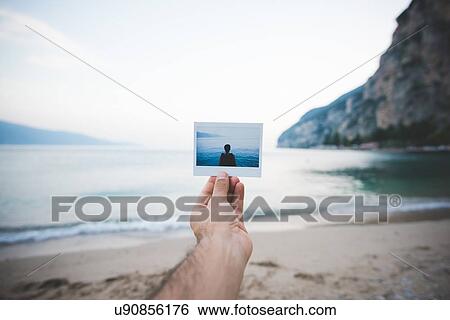 Person holding up photograph, Lake Garda, Italy View Large Photo Image Stock Photograph - Person holding up photograph, Lake Garda, Italy. Fotosearch