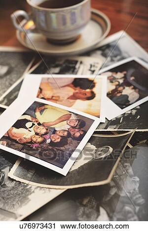 Pile of family photographs on table, next to tea cup View Large Photo Image Stock Image - Pile of family photographs on table, next to tea cup. Fotosearch