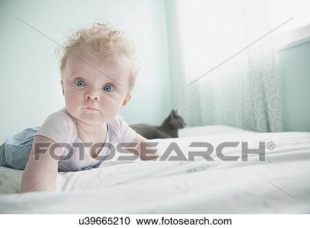 Stock Image - Portrait of baby girl lying on front. Fotosearch
