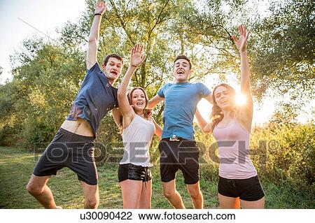 Stock Image - Portrait of group of friends in rural environment, fooling around, smiling. Fotosearch