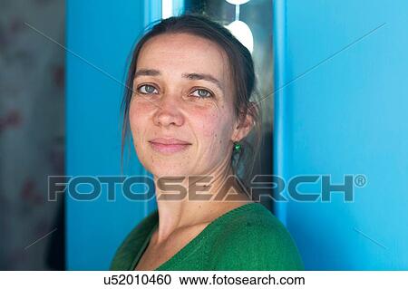Stock Image - Portrait of mid adult woman in doorway looking at camera. Fotosearch
