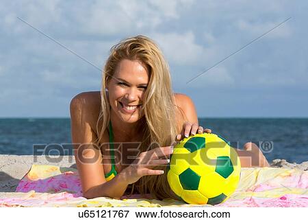 Portrait of woman wearing bikini lying on beach with soccer ball, Miami Beach, Florida, USA View Large Photo Image Stock Photo - Portrait of woman wearing bikini lying on beach with soccer ball, Miami Beach, Florida, USA. Fotosearch