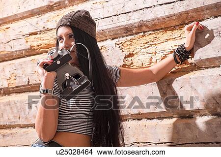 Portrait of young female photographer in front of wooden wall View Large Photo Image Picture - Portrait of young female photographer in front of wooden wall. Fotosearch