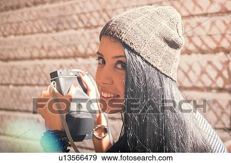 Portrait of young female photographer looking over her shoulder View Large Photo Image Stock Photo - Portrait of young female photographer looking over her shoulder. Fotosearch