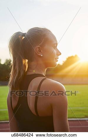 Portrait of young female runner on sunlit race track View Large Photo Image Picture - Portrait of young female runner on sunlit race track. Fotosearch