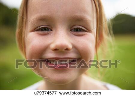 Portrait of young girl in field, smiling, close-up View Large Photo Image Stock Photo - Portrait of young girl in field, smiling, close-up. Fotosearch