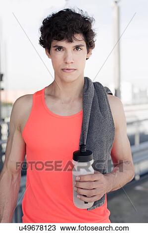 Portrait of young male runner holding water bottle View Large Photo Image Stock Image - Portrait of young male runner holding water bottle. Fotosearch