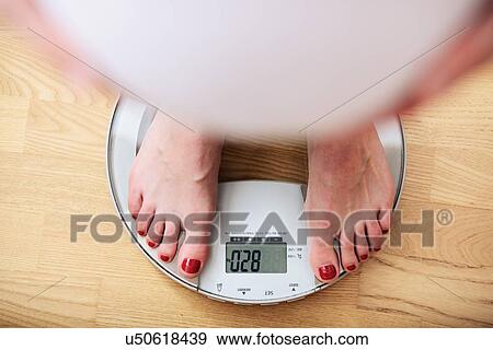 Pregnant woman standing on scales, overhead view View Large Photo Image Stock Photo - Pregnant woman standing on scales, overhead view. Fotosearch
