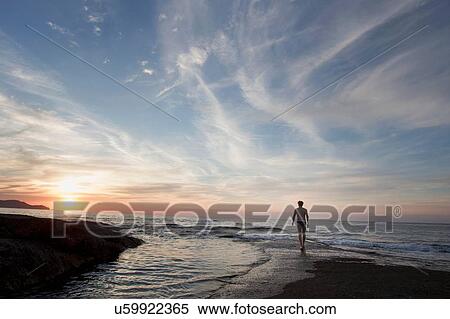 Rear silhouetted view of mature man on beach at sunset, Calvi, Corsica, France View Large Photo Image Stock Photography - Rear silhouetted view of mature man on beach at sunset, Calvi, Corsica, France. Fotosearch