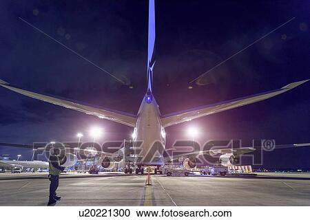 Stock Image - Rear view of A380 aircraft on runway at airport at night. Fotosearch