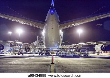 Rear view of A380 aircraft on runway at airport at night View Large Photo Image Stock Photo - Rear view of A380 aircraft on runway at airport at night. Fotosearch