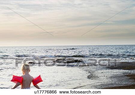 Rear view of female toddler wearing inflatable armbands at coast, Calvi, Corsica, France View Large Photo Image Stock Photograph - Rear view of female toddler wearing inflatable armbands at coast, Calvi, Corsica, France. Fotosearch