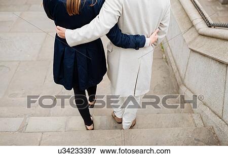 Rear view of romantic couple walking down city steps View Large Photo Image Stock Photo - Rear view of romantic couple walking down city steps. Fotosearch