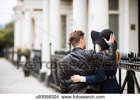 Picture - Rear view of romantic young couple strolling on street, London, England, UK. Fotosearch