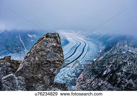 Stock Photo - Rock formation and low cloud, Eggishorn, Switzerland. Fotosearch