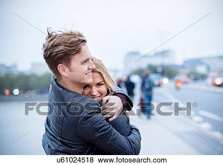 Romantic couple hugging each other on city street View Large Photo Image Stock Photo - Romantic couple hugging each other on city street. Fotosearch