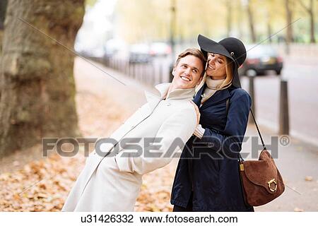 Stock Image - Romantic young couple fooling around in park, London, England, UK. Fotosearch