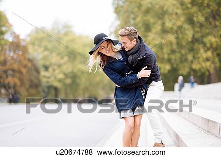 Romantic young couple fooling around in park, London, England, UK View Large Photo Image Stock Photo - Romantic young couple fooling around in park, London, England, UK. Fotosearch