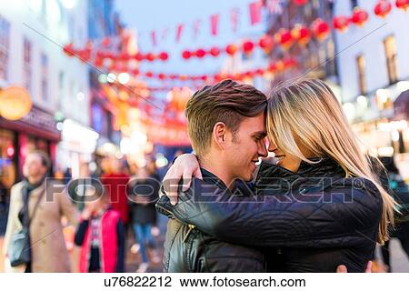 Stock Image - Romantic young couple hugging, Chinatown, London, England, UK. Fotosearch