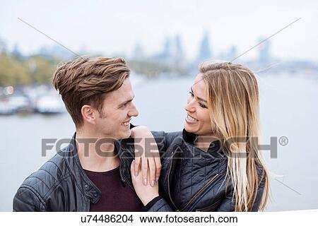 Picture - Romantic young couple in front of Thames river, London, England, UK. Fotosearch