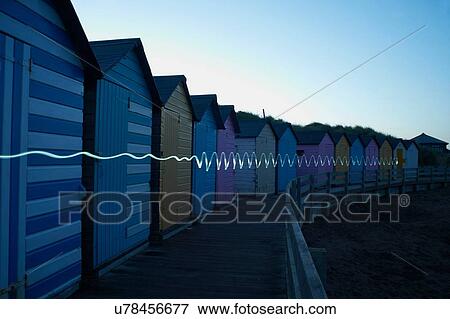 Row of colourful beachhuts at dusk, with light trail, Bude, Cornwall, UK View Large Photo Image Stock Photo - Row of colourful beachhuts at dusk, with light trail, Bude, Cornwall, UK. Fotosearch
