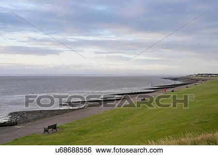 Stock Photograph - Rows of park benches on Solway Firth waterfront, Silloth, Cumbria, UK. Fotosearch
