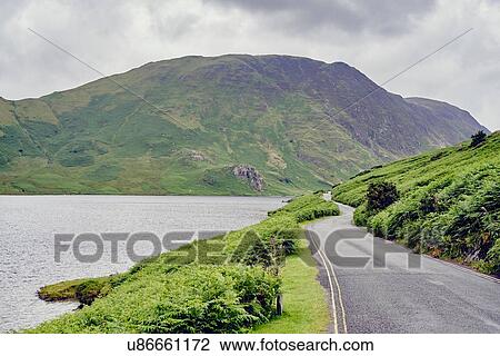 Stock Image - Rural lakeside road, Lake Buttermere, Cumbria, UK. Fotosearch