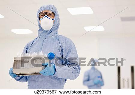 Stock Photo - Scientist carrying tray of test tubes in laboratory. Fotosearch