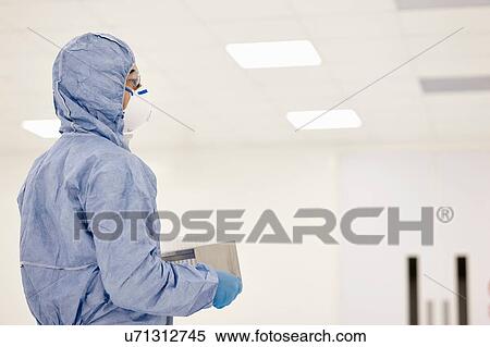 Stock Photography - Scientist carrying tray of test tubes in laboratory. Fotosearch