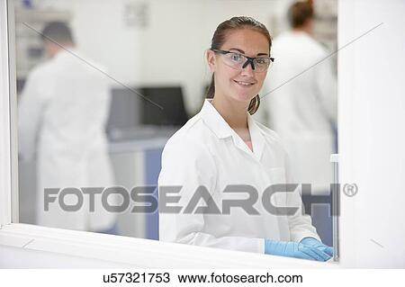 Scientist smiling in laboratory, colleagues working in background View Large Photo Image Stock Image - Scientist smiling in laboratory, colleagues working in background. Fotosearch