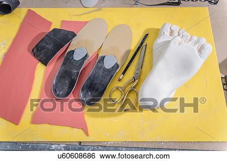Stock Photograph - Shoe insoles made from plaster casts of feet in medical factory. Fotosearch