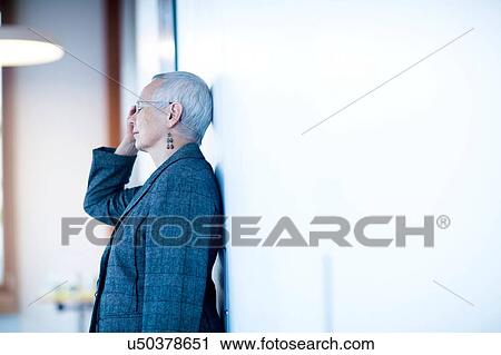 Side view of mature woman leaning against wall, hand on head, eyes closed looking stressed View Large Photo Image Stock Image - Side view of mature woman leaning against wall, hand on head, eyes closed looking stressed. Fotosearch