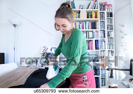 Side view of mid adult woman ironing, looking down View Large Photo Image Stock Image - Side view of mid adult woman ironing, looking down. Fotosearch