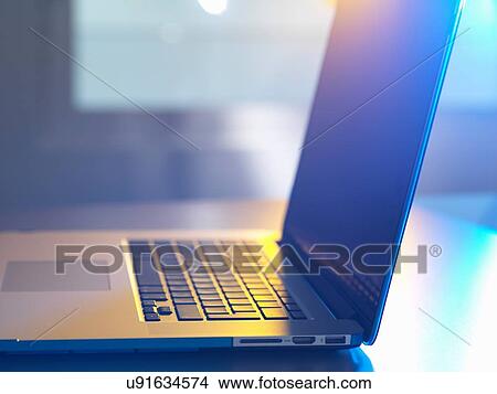 Side view of open laptop on desk View Large Photo Image Picture - Side view of open laptop on desk. Fotosearch