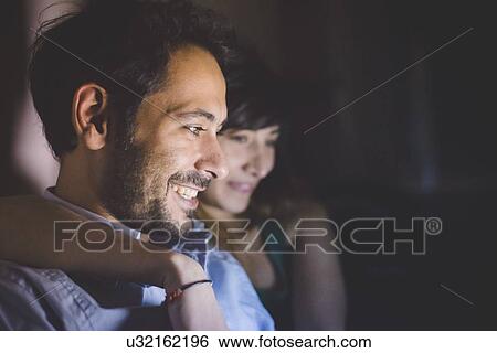 Side view of young couples head and shoulders illuminated from laptop computer screen smiling View Large Photo Image Stock Photograph - Side view of young couples head and shoulders illuminated from laptop computer screen smiling. Fotosearch