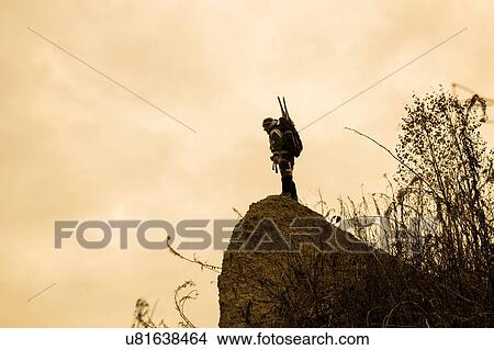 Silhouetted view of male looking down from rock, Ural, Russia View Large Photo Image Picture - Silhouetted view of male looking down from rock, Ural, Russia. Fotosearch