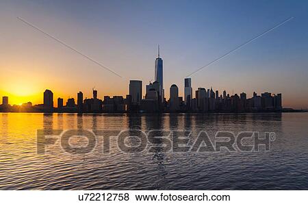 Stock Photo - Silhouetted view of Manhattan financial district skyline at sunset, New York, USA. Fotosearch