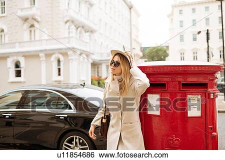 Stylish young woman next to red post box, London, England, UK View Large Photo Image Stock Photograph - Stylish young woman next to red post box, London, England, UK. Fotosearch