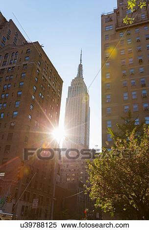 Stock Photography - Sunlit view of Empire State building from Park Avenue, New York, USA. Fotosearch