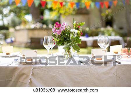 Stock Photo - Table with flowers set for party in garden. Fotosearch