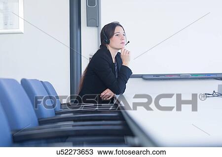 Telephonist contemplating in meeting room View Large Photo Image Stock Image - Telephonist contemplating in meeting room. Fotosearch