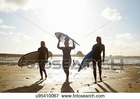 Three female friends on beach, holding surfboards View Large Photo Image Stock Photo - Three female friends on beach, holding surfboards. Fotosearch