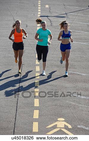 Three young female runners running in parking lot View Large Photo Image Stock Photograph - Three young female runners running in parking lot. Fotosearch